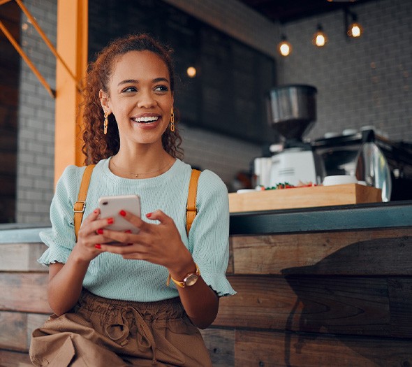 Smiling woman sitting on barstool at restaurant