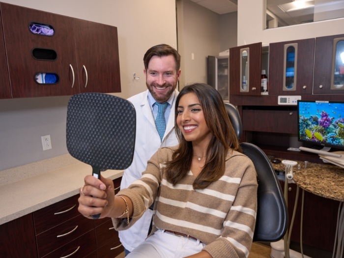 Dentist and patient looking in handheld mirror together