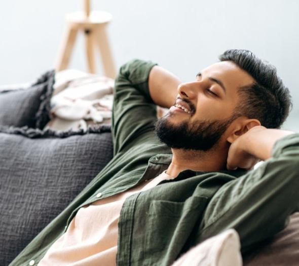 A man relaxing on the couch while at home