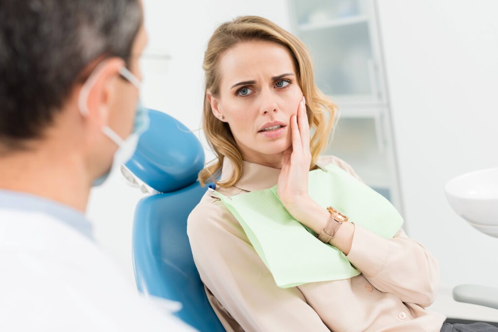 Woman with toothache looking at dentist